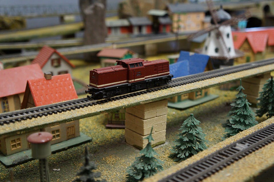 Modellbahn-Landschaft mit Häusern, Gleisen und einer Lokomotive
